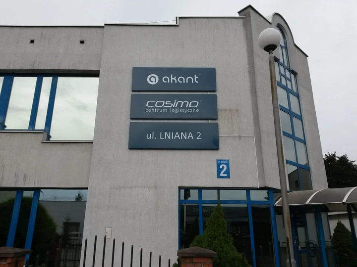 Kasetony z grafiką wiszące na ścianie budynku firmy Akant.