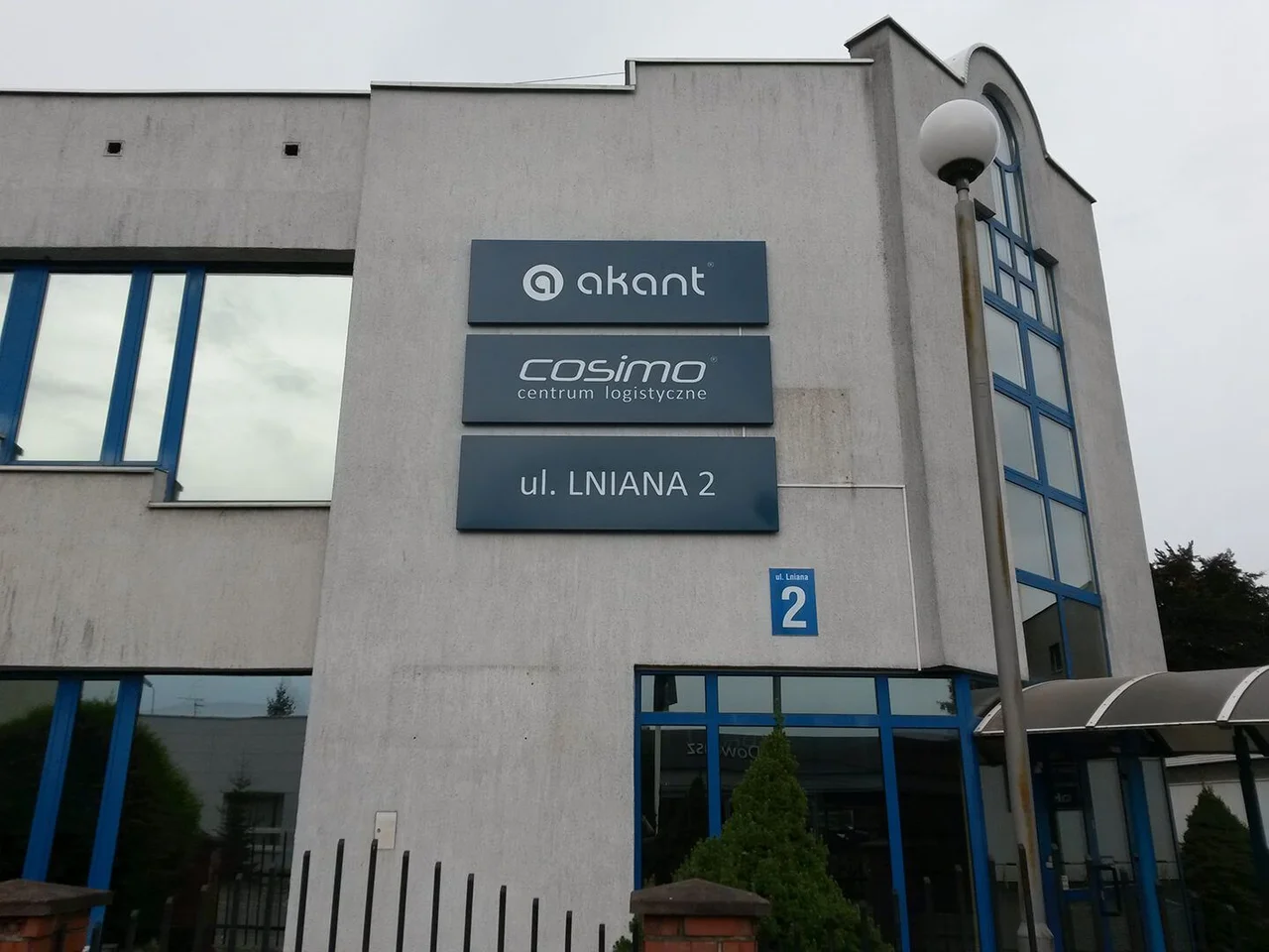 Kasetony z grafiką wiszące na ścianie budynku firmy Akant.